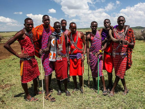 a group of maasai worrior men wearing traditional clothing